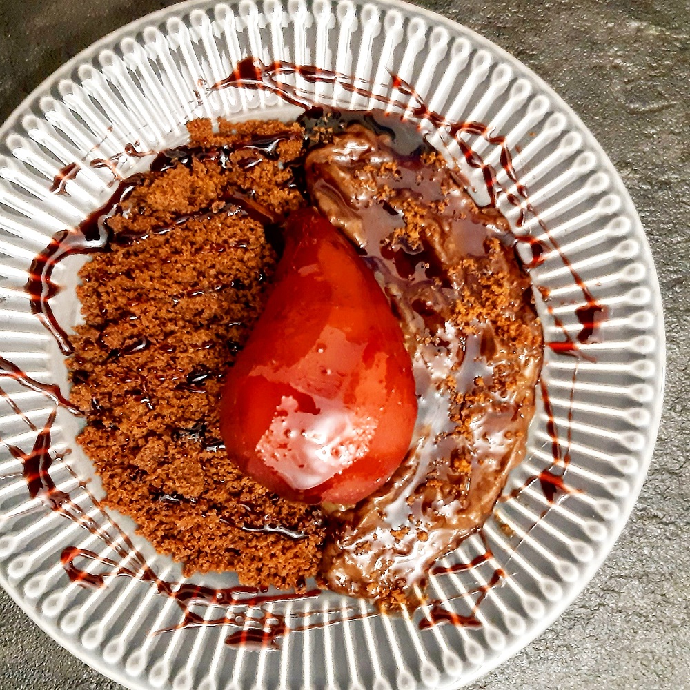 PERE SPEZIATE AL VINO ROSSO SU SABBIA AL CACAO E CREMA AL CIOCCOLATO